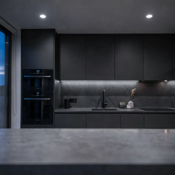 A kitchen lit by newly installed downlights at dusk